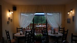 Un comedor con mesas y sillas y una ventana. en Casa Mon Reve, en Bran