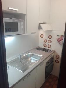 a small kitchen with a sink and a microwave at Ski-Garden in Mezzana +49 photos