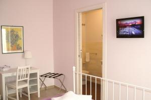 a room with a crib and a desk with a television on the wall at Il gelsomino in Scicli