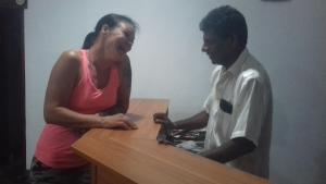 a man and a woman standing next to a table at Prasad Suomi Villa in Matara
