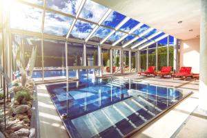 an indoor swimming pool with a glass ceiling at Impuls Hotel Tirol in Bad Hofgastein