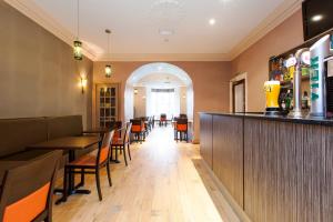 a restaurant with tables and chairs and a bar at The Abbey Lodge Hotel in Bradford