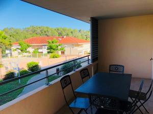 uma varanda com uma mesa e cadeiras e uma vista em Les Parasols d'Argens em Roquebrune-sur-Argens