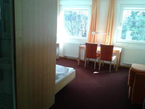 Zimmer mit einem Tisch, 2 Stühlen und einem Fenster in der Unterkunft Haus der Begegnung in Innsbruck