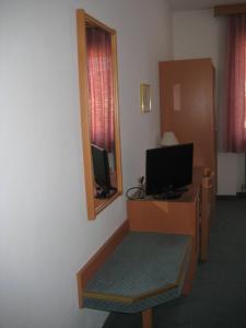 a hotel room with a tv and a desk with a monitor at Gasthof Zur Linde in Neuhofen an der Ybbs