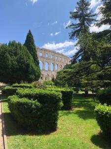 un edificio con un montón de arbustos en el césped en Magnolia en Pula