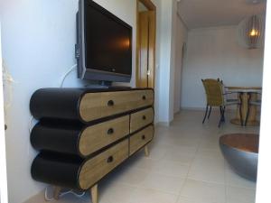 telewizor na komodzie z telewizorem w obiekcie Mirador De Aguamarina w mieście Campoamor +25 zdjęć