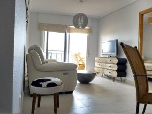 salon z krzesłem i telewizorem w obiekcie Mirador De Aguamarina w mieście Campoamor