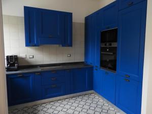 uma cozinha azul com armários e electrodomésticos azuis em Fantastic Luxury Apartments in Lerici em Lerici