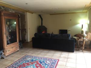 a living room with a black couch and a fireplace at O Candil De Santa Ana in Pontevedra