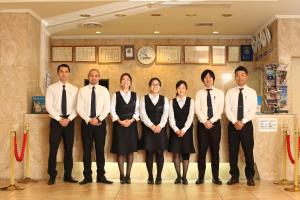 Hotel New Yokosuka في يوكوسوكا: مجموعة من الناس واقفين في غرفة