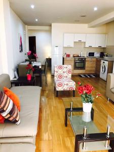 uma sala de estar e cozinha com um sofá e uma mesa em Ithaki Phinikoudes Apartments No. 106 em Lárnaca