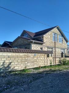 a brick house with a fence in front of it at Sweet home Gusar. in Qusar
