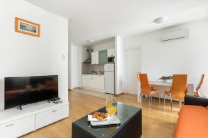 un soggiorno con TV e tavolo con cibo di Apartment Marcela With Private Parking a Spalato (Split)