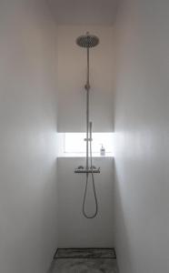a shower in a room with a light on the wall at SLEEEP HKG Gough St in Hong Kong
