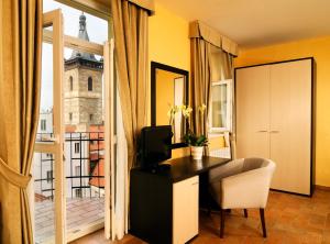 um quarto com uma secretária e uma varanda com uma torre em Hotel Praga 1 em Praga