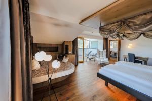 a bedroom with two beds and a living room at Hotel Schlosswirt in Schenna