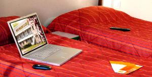 a laptop computer sitting on top of a bed at Premiere Classe Hotel Breda in Breda