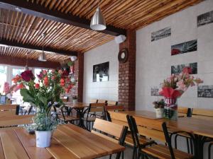 a restaurant with wooden tables and chairs and flowers at Kosmos 519 in Zatoka