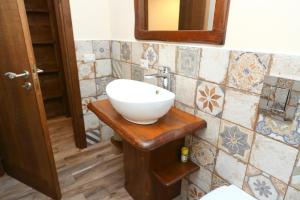 een badkamer met een witte wastafel op een houten aanrecht bij Campeggio Sanfilippo in Cefalù