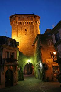 uma torre de tijolos no meio de uma rua em A La Porte Saint Jean em La Souterraine