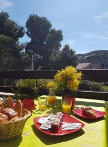 een tafel met twee borden eten en een mand brood bij Hôtel**résidence BEAR in Port-Vendres