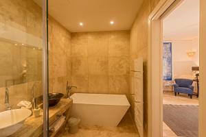 a bathroom with a tub and a sink at The Snop House in Senglea +37 photos