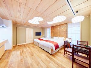 a large bedroom with a large bed and wooden floors at Sunrise Suites in Kyoto