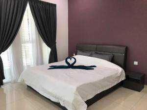 a bedroom with a bed with a heart decoration on it at Greenville Homestay in Balik Pulau