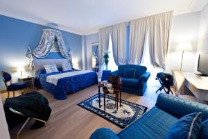 a blue bedroom with a bed and a blue couch at OSTUNI PALACE - Hotel Bistrot & SPA in Ostuni