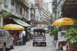 un carro con una sombrilla en una calle de la ciudad en Peace Factory Hostel, en Bangkok
