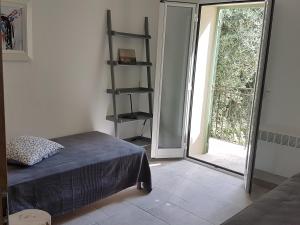 1 dormitorio con 1 cama y puerta corredera de cristal en 205 route de la turbie en Èze