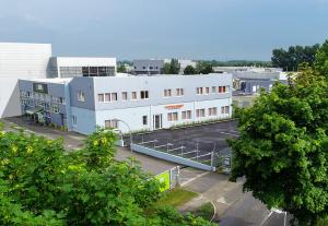 a large white building with a parking lot at WinBudget "bed&breakfast" Guntramsdorf in Guntramsdorf