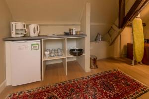 a small kitchen with a refrigerator and a rug at B&B Next Door in Bruges