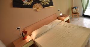 una camera con un letto bianco e due comodini di Residence Adriatico a Silvi Marina