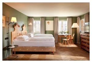 a bedroom with two beds and a desk in it at Gasthof Hirschen Schwarzenberg in Schwarzenberg im Bregenzerwald