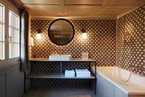 La salle de bains est pourvue d'une baignoire, d'un lavabo et d'un miroir. dans l'établissement Gasthof Hirschen Schwarzenberg, à Schwarzenberg im Bregenzerwald