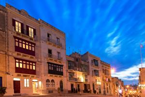 a row of buildings on a street at night at The Snop House in Senglea