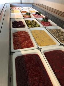 a buffet line of different types of food in trays at Rørosvidda Hotell in Røros