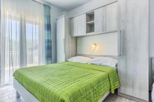 カシュテラにあるApartments & Bungalows Ivanovićのベッドルーム1室(大型ベッド1台、緑の毛布付)