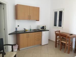 a kitchen with a sink and a microwave and a table at Eugenia travasarou sea view appartments in Diakofti