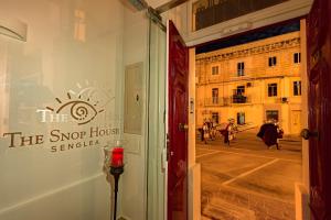 een raam van een winkel met uitzicht op een binnenplaats bij The Snop House in Senglea