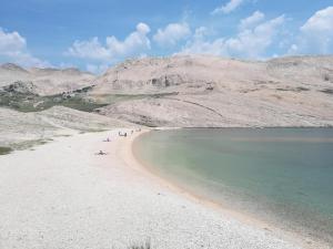 a group of people on a beach near the water at LARA & VITO in Metajna