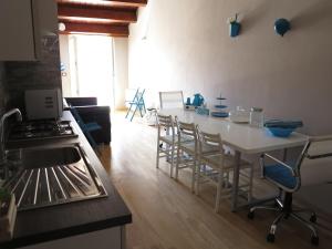 kuchnia z białym stołem i krzesłami w pokoju w obiekcie Original b&b w mieście Porto Torres
