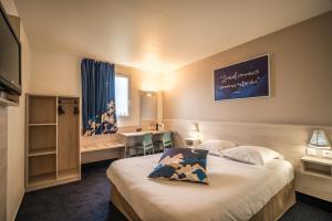 um quarto de hotel com uma cama e uma secretária em Ace Hôtel Toulouse Blagnac em Cornebarrieu