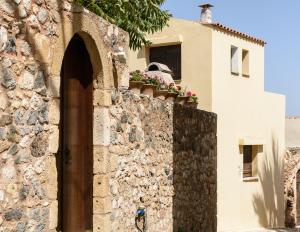 un edificio con una pared de piedra junto a una casa en Ariadni Stone House with private pool, en Kolimvárion