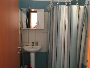 a bathroom with a sink and a shower curtain at Eugenia travasarou sea view appartments in Diakofti