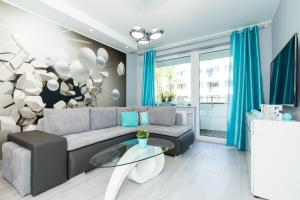 コウォブジェクにあるApartamenty BLIŻEJ MORZA Siłownia i Taras Widokowy Kołobrzeg by Noclegi Rentersのソファとテーブルのあるリビングルーム