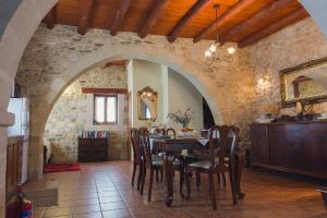 cocina y comedor con mesa y sillas en Ariadni Stone House with private pool, en Kolimvárion