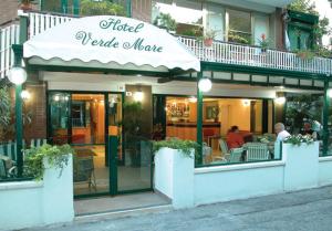 Hotel Verdemare في ريميني: مطعم فيه ناس جالسين على طاولات خارجه